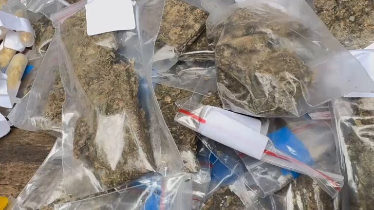 Viaturas da Polícia Militar em operação contra o tráfico de drogas, com material apreendido em destaque.
