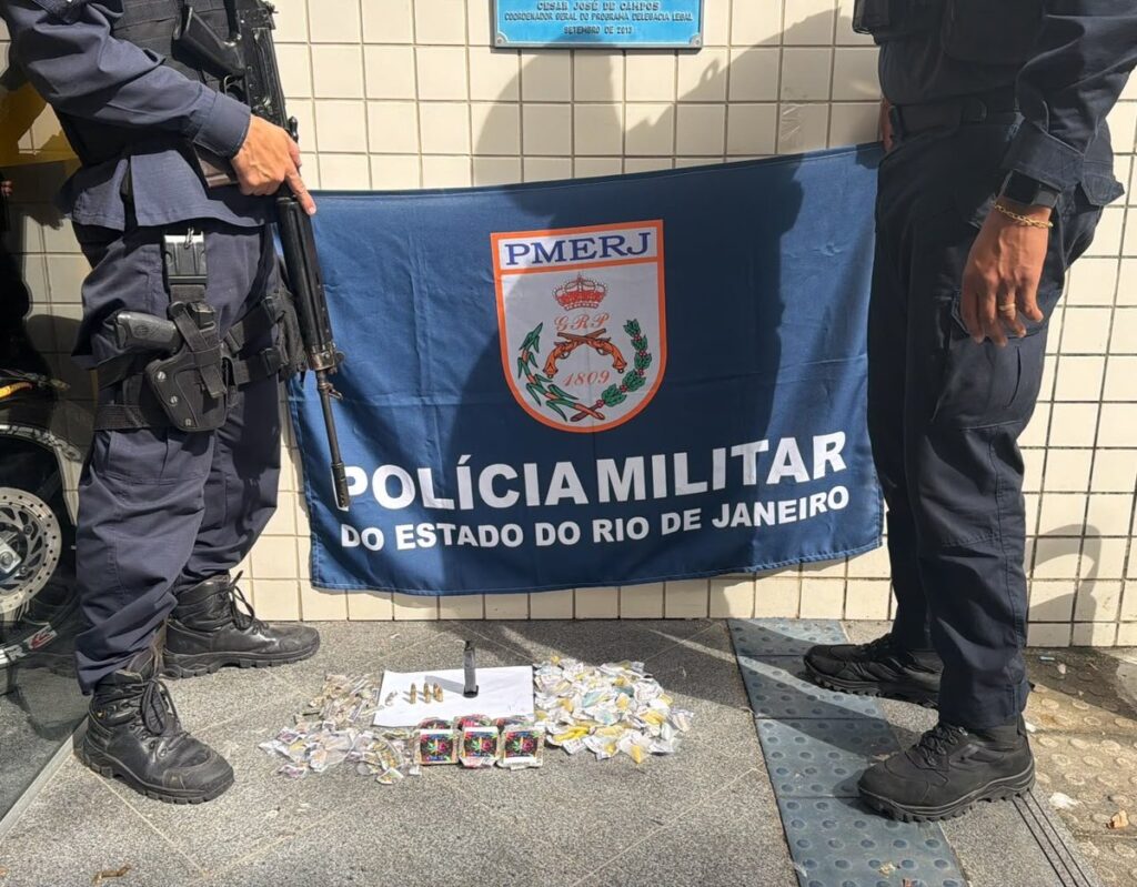 Policiais militares mostram drogas, munições e um carregador de pistola apreendidos em Niterói, RJ.