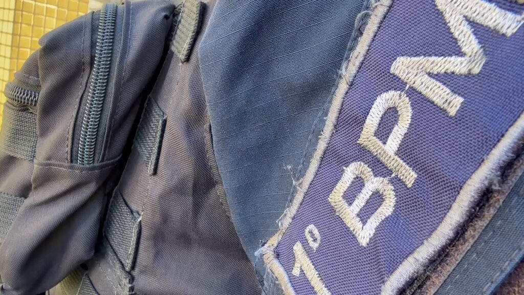 Policiais militares exibem pistola e grandes quantidades de maconha, crack e cocaína apreendidas em São Gonçalo.