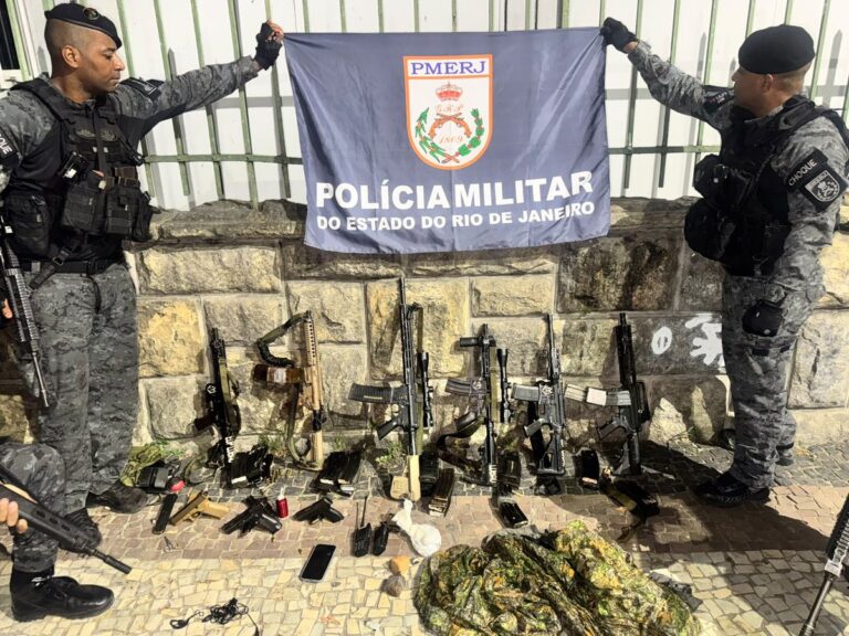 Policial militar do Rio de Janeiro com fuzis apreendidos em operação no estado.