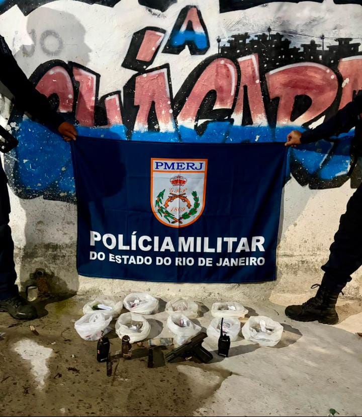 Policiais militares exibindo drogas, pistola e granada apreendidos em operação contra o tráfico em Niterói.