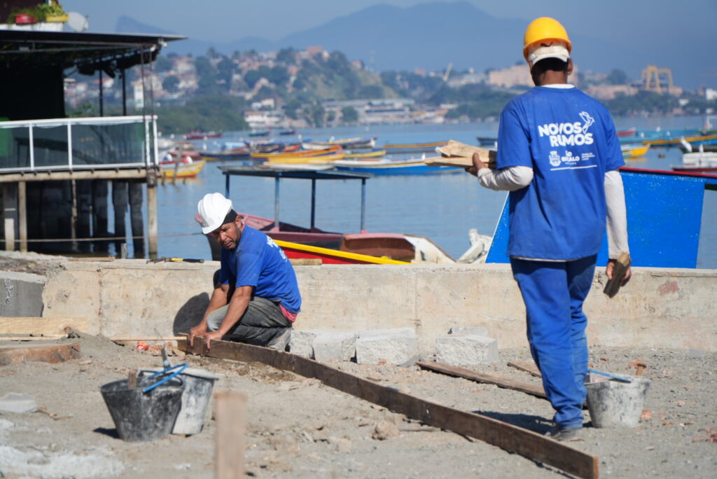 Imagem da orla da Praia das Pedrinhas em São Gonçalo durante obras de revitalização, com calçadas e pilares de pergolados.
