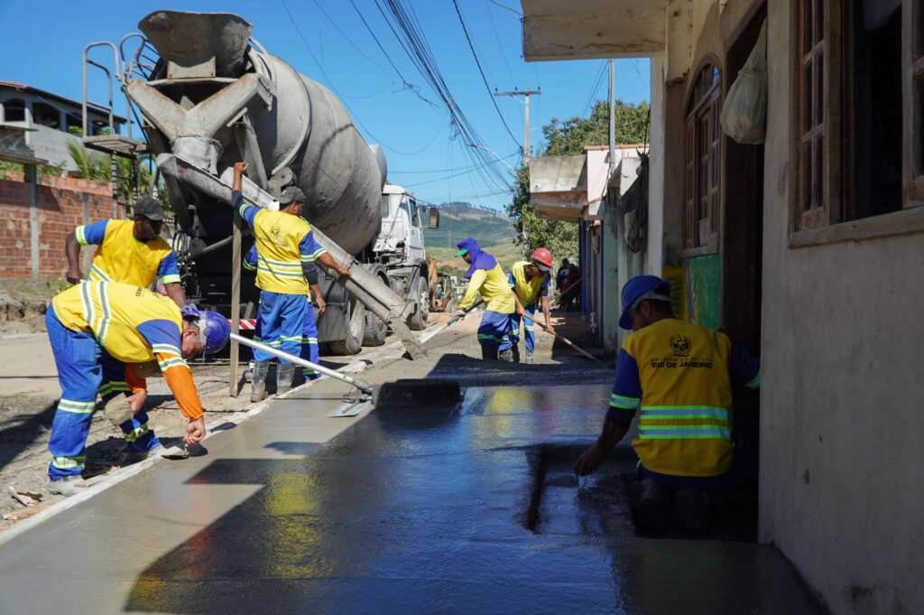 Máquinas e trabalhadores atuam na pavimentação de uma rua no bairro Santa Izabel, São Gonçalo.