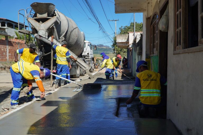 Máquinas e trabalhadores atuam na pavimentação de uma rua no bairro Santa Izabel, São Gonçalo.