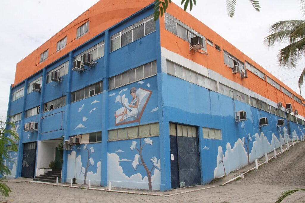 Jovens e adultos estudando em sala de aula, com foco em material didático, representando o programa EJA em São Gonçalo.