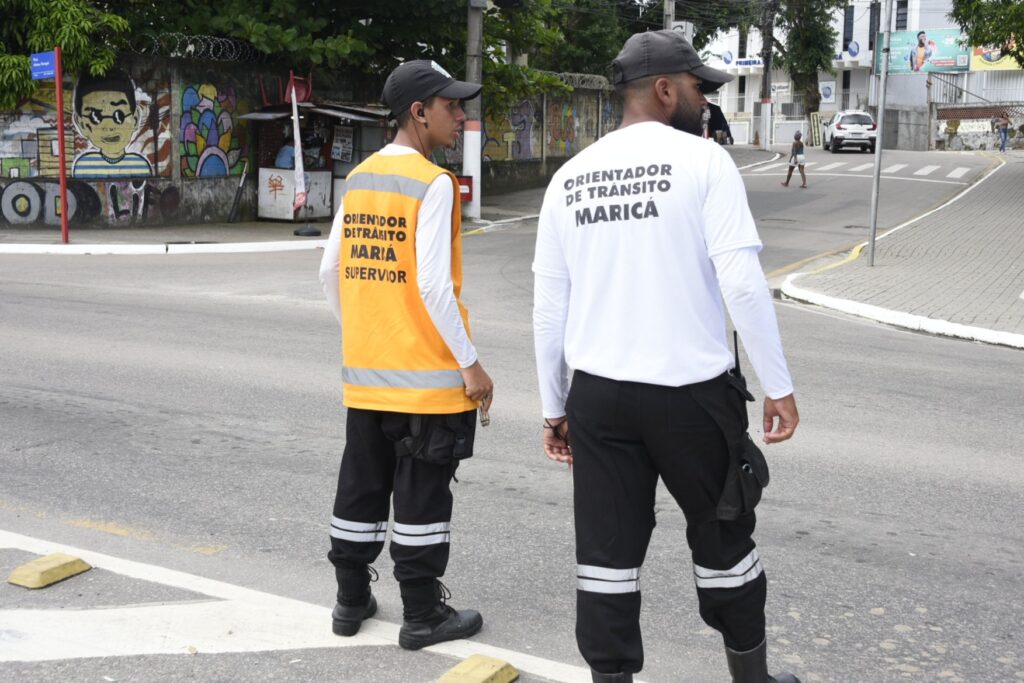 Agentes de trânsito orientam motoristas em rua movimentada de Maricá.