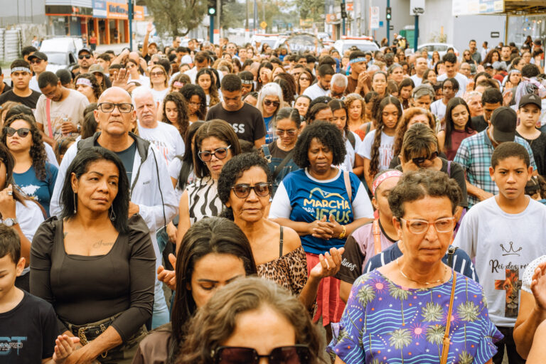 Fiéis em caminhada durante a Marcha para Jesus em Maricá, com faixas e bandeiras.