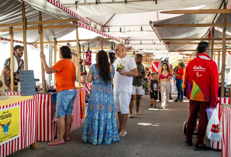 Produtores rurais em Feira da Agricultura Familiar em Maricá, com barracas e produtos frescos