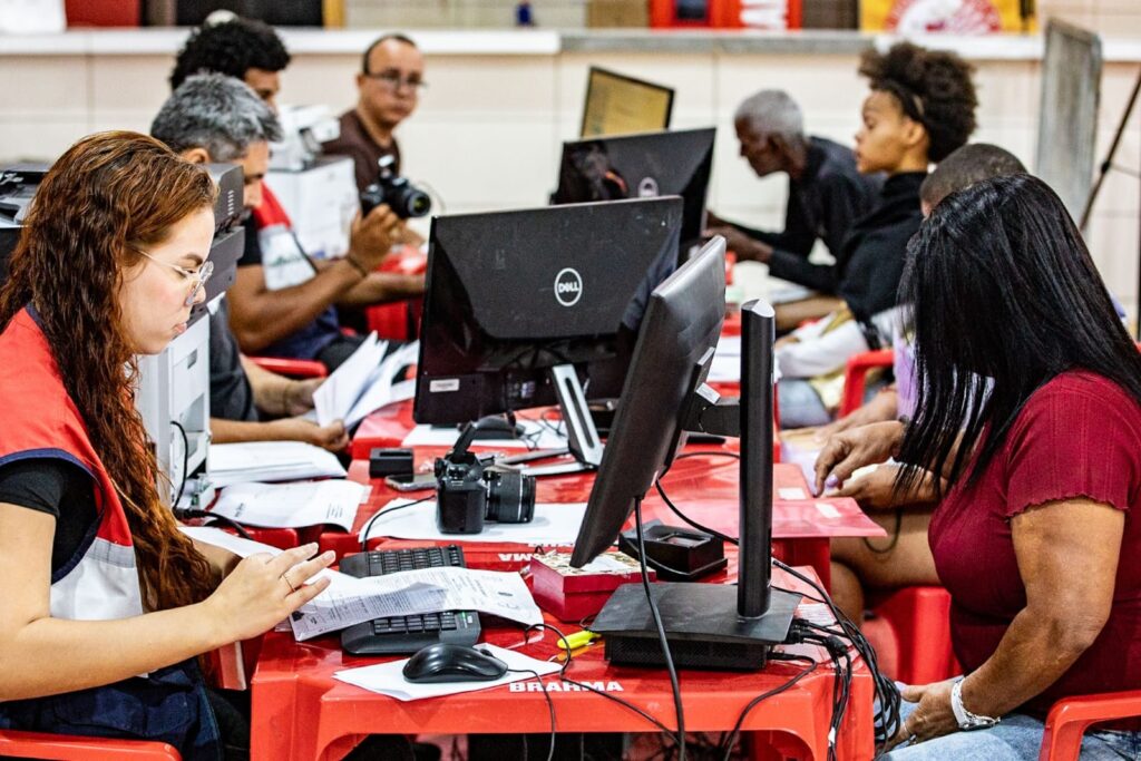 Moradores recebem atendimento em ação social da Prefeitura de Maricá em quadra de escola de samba.