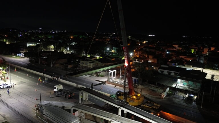 Equipe da Prefeitura de Maricá içando estrutura central de passarela em construção na RJ-106.