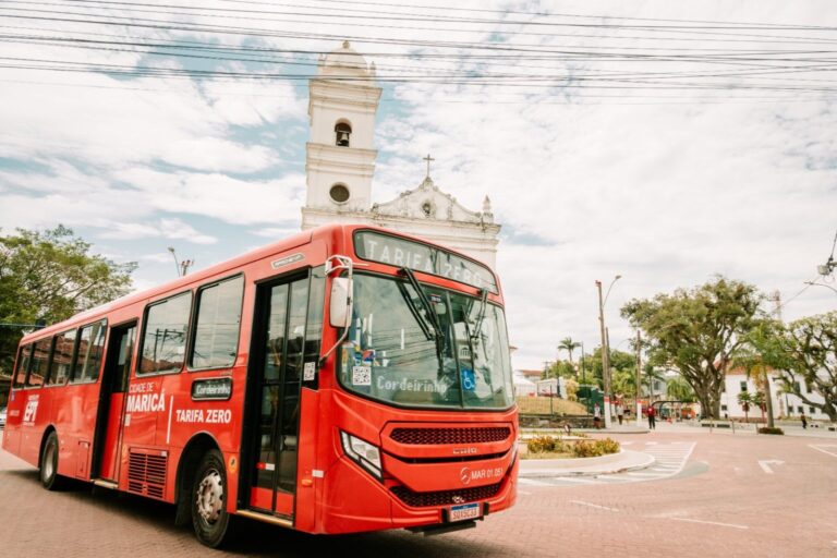 Ônibus vermelho da EPT em Maricá, circulando à noite para atender à demanda da Festa da Padroeira.