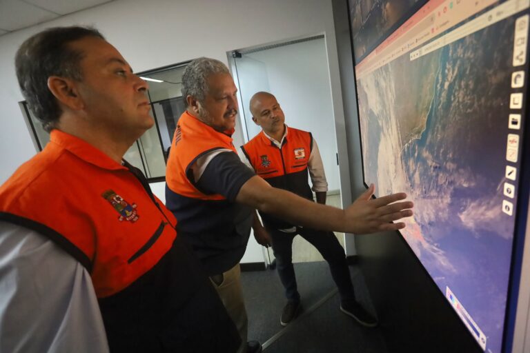 Equipe da Defesa Civil de Niterói monitora telas com dados meteorológicos em centro de operações.