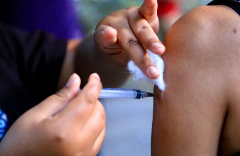 Profissional de saúde aplicando vacina em criança durante campanha de multivacinação em Niterói.