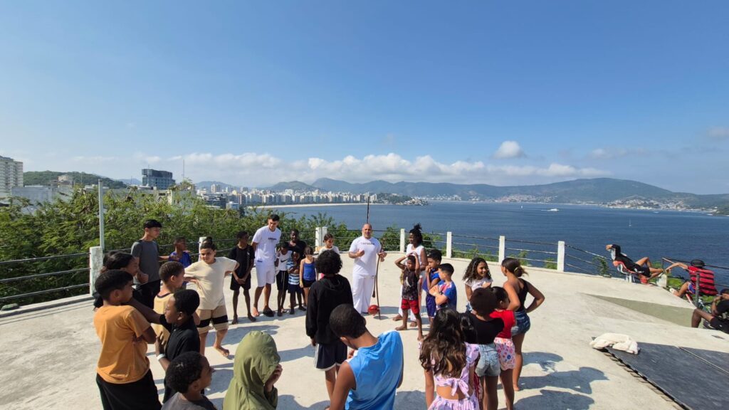 Crianças, jovens e adultos praticam capoeira em espaço cultural no Morro do Palácio em Niterói.