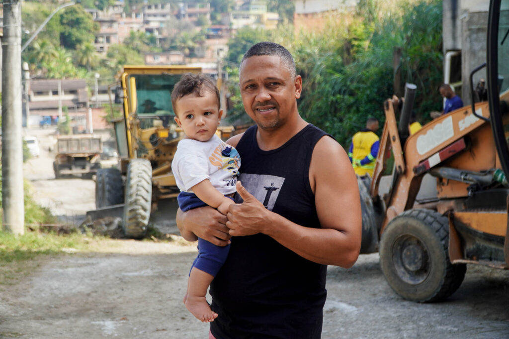 Trabalhadores instalam manilhas para rede de drenagem em rua de São Gonçalo, parte das obras de infraestrutura.