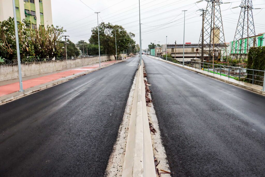 Obras do projeto MUVI em São Gonçalo, mostrando a nova ponte sobre o Rio Alcântara em fase de acabamento, com máquinas e trabalhadores.