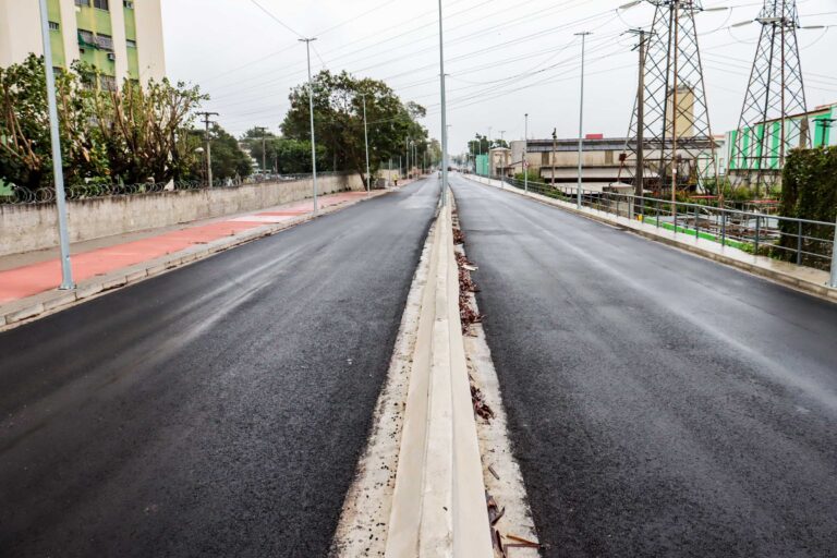 Obras do projeto MUVI em São Gonçalo, mostrando a nova ponte sobre o Rio Alcântara em fase de acabamento, com máquinas e trabalhadores.