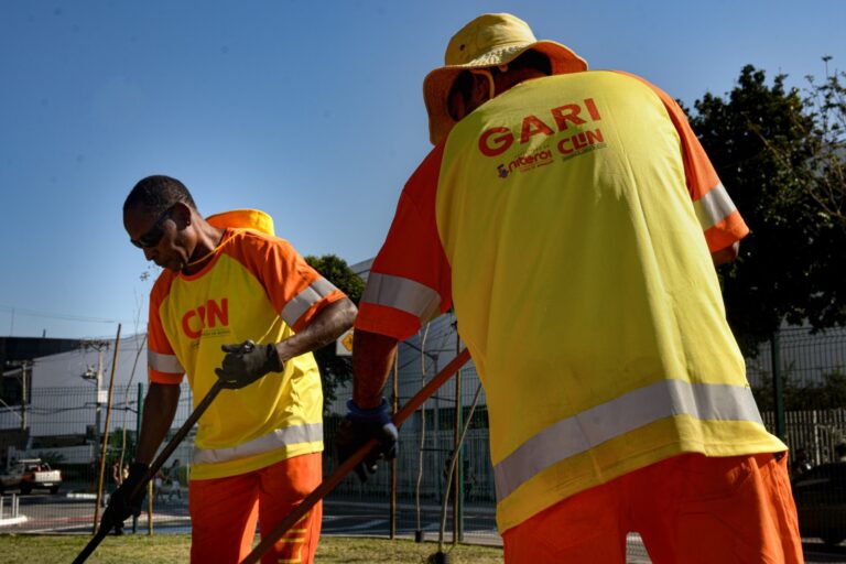 Garis de Niterói vestindo os novos uniformes azuis de tecido dry fit durante o trabalho de limpeza urbana.