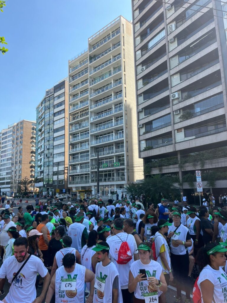 Pessoas participando de uma corrida e caminhada inclusiva em Niterói na Praia de Icaraí.
