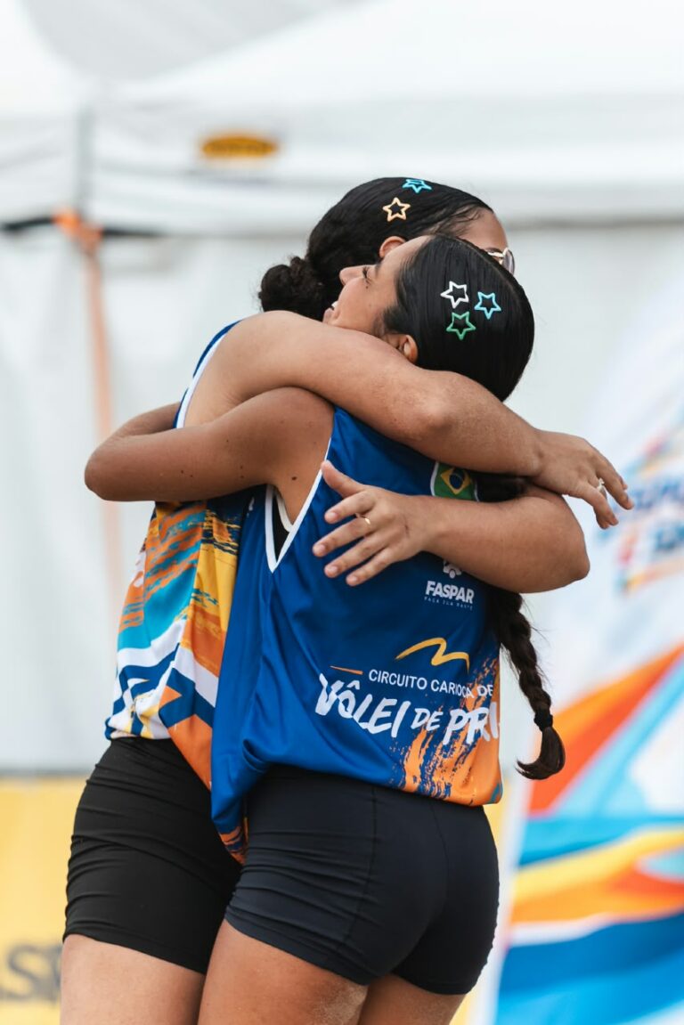 Jovens atletas jogam vôlei de praia na orla de Icaraí, Niterói, durante evento esportivo.