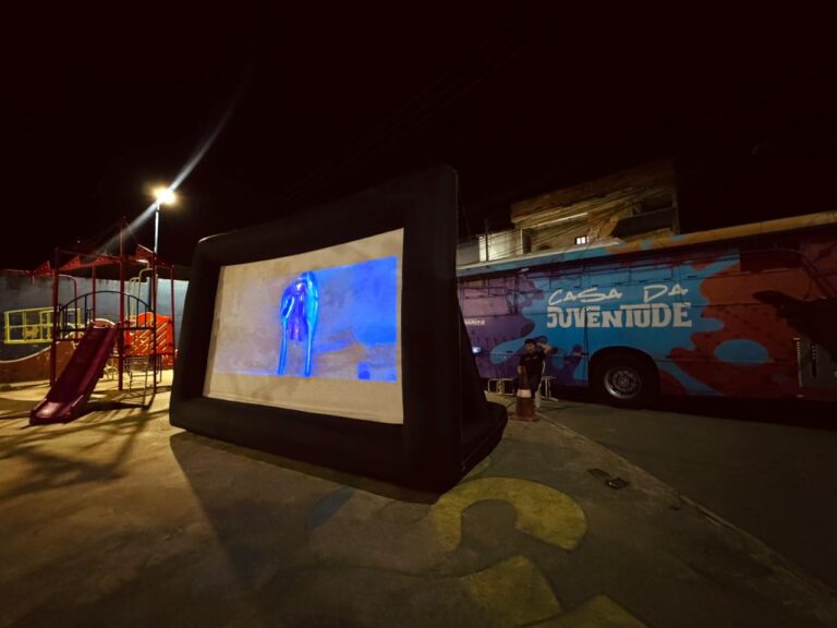 Crianças e famílias assistem a filme em sessão de cinema itinerante em Inoã, Maricá.