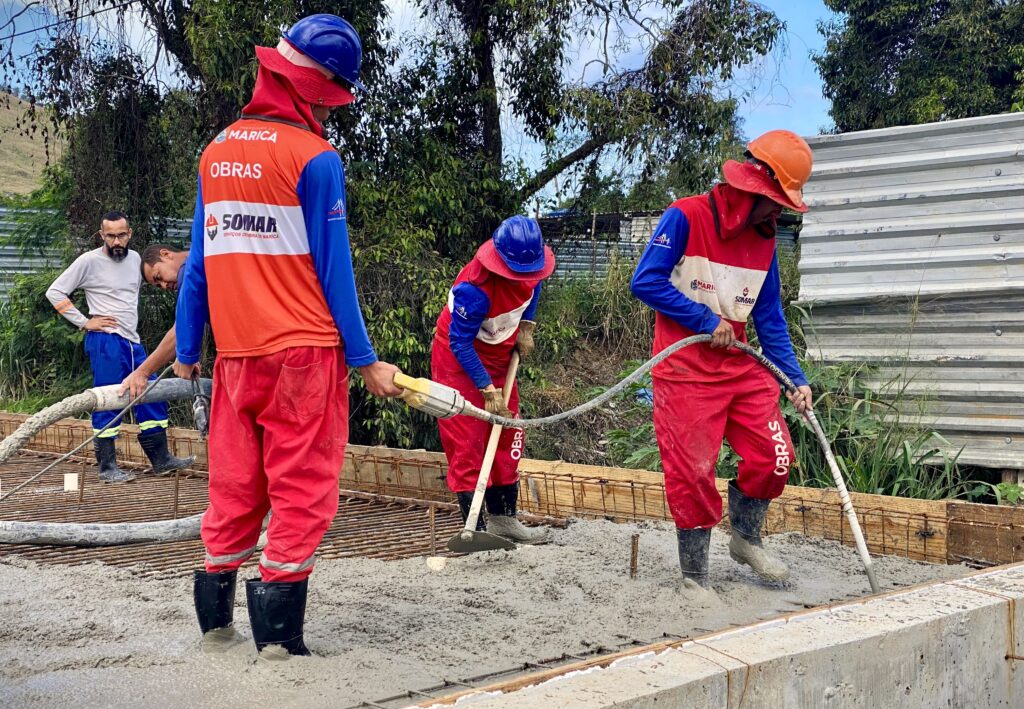 Obras de construção de ponte em Maricá, Inoã, com máquinas e trabalhadores em canteiro.