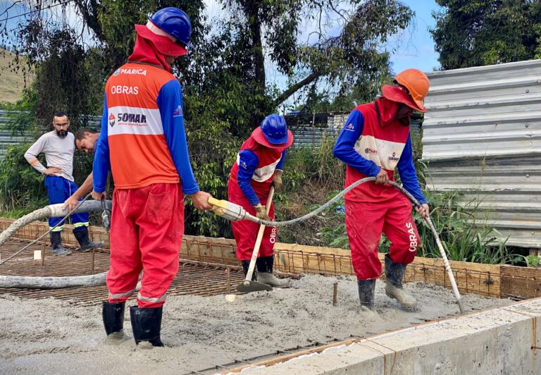 Obras de construção de ponte em Maricá, Inoã, com máquinas e trabalhadores em canteiro.