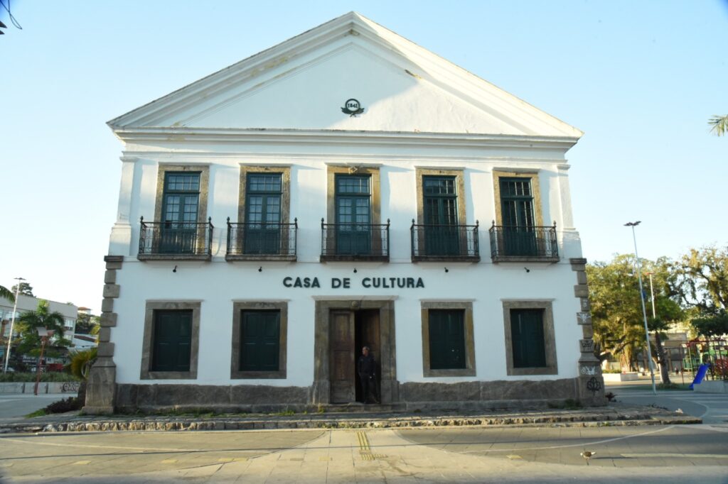 Grupo de pessoas em visita mediada ao Museu Histórico de Maricá, explorando a história local e documentos.