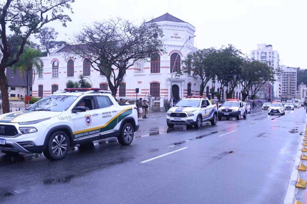 Prefeito Rodrigo Neves e general assistem ao desfile de 7 de Setembro em Niterói sob chuva.