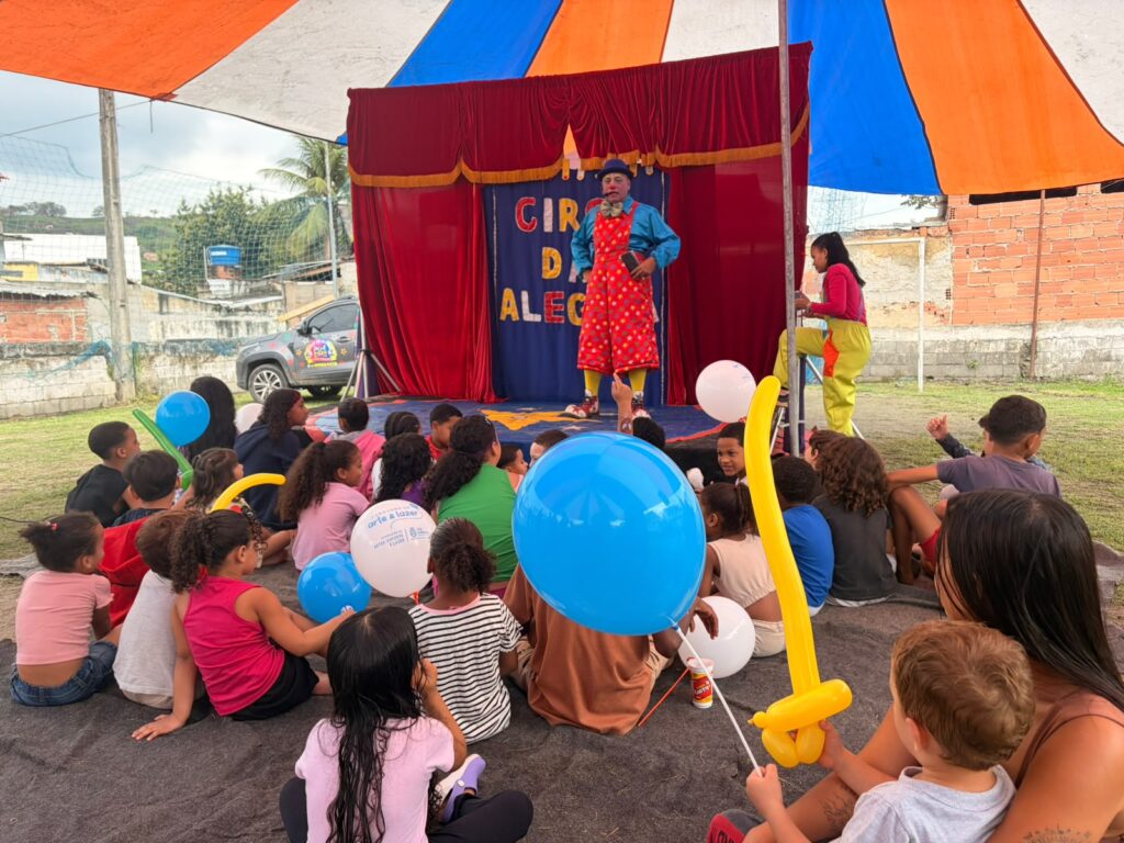 Crianças brincam em brinquedos infláveis e interagem com personagens em evento da Caravana de Arte e Lazer em São Gonçalo.