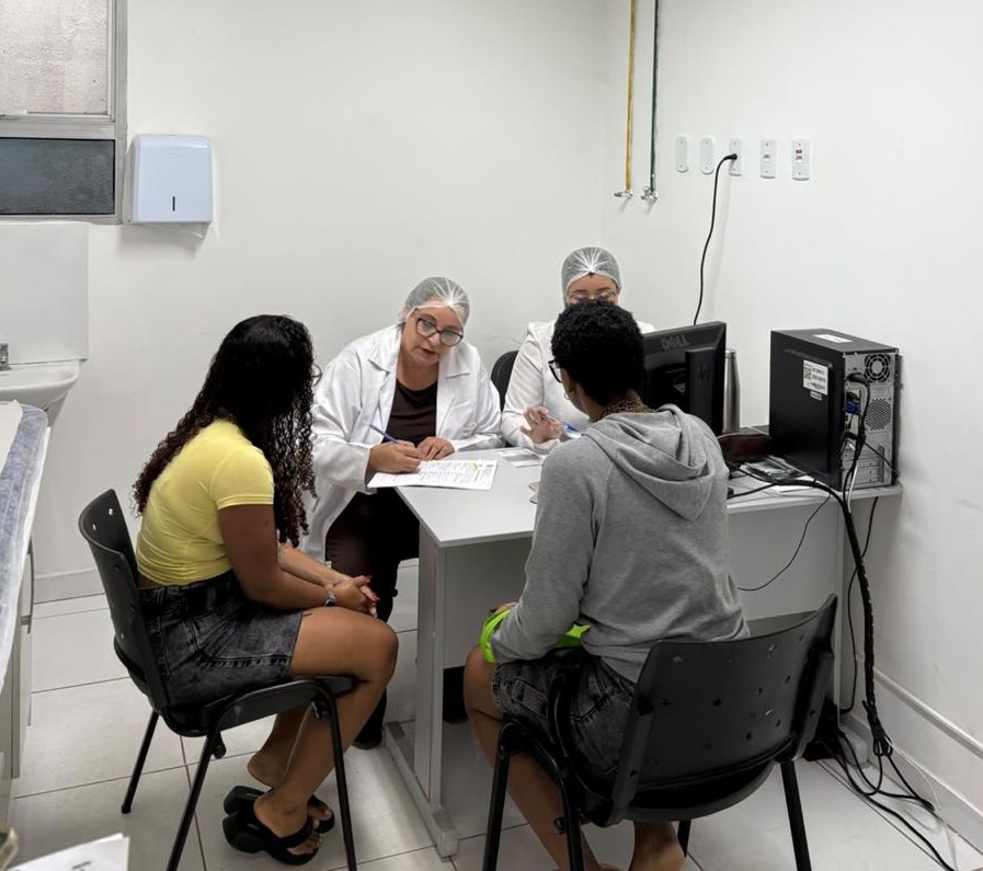 Mulher recebendo implante contraceptivo subdérmico no braço durante mutirão em São Gonçalo.