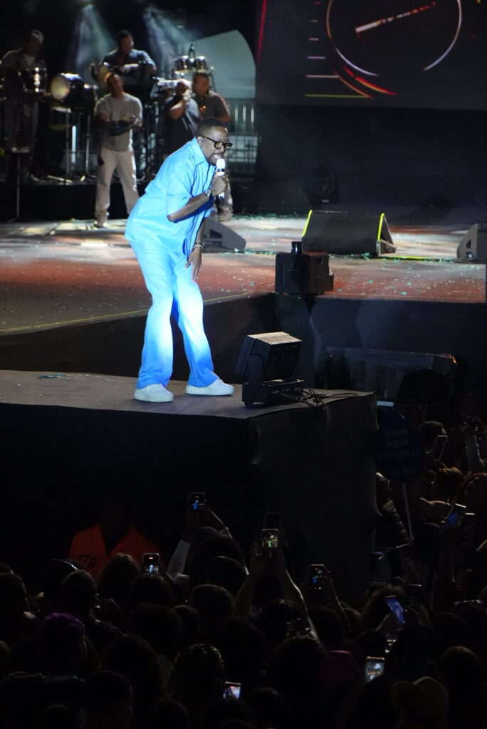 Belo e Mumuzinho se apresentando no palco do São Gonçalo Fest 2026 para uma multidão empolgada.