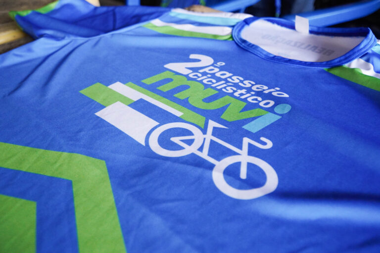 Entrega de kits para o 2º Passeio Ciclístico do MUVI em São Gonçalo, com ciclistas e bicicleta.