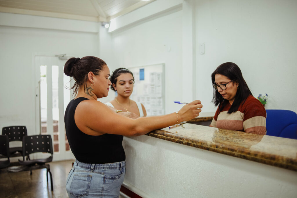 Pessoas em ambiente de atendimento, possivelmente em busca de emprego, representando as vagas em Maricá.