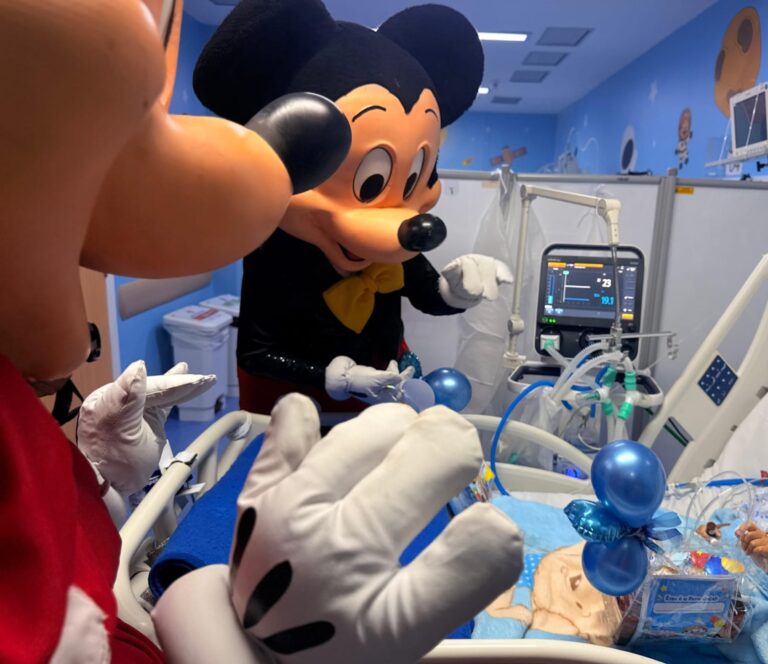 Crianças internadas recebendo kits e visita de profissionais fantasiados em hospital de Maricá no Dia das Crianças.
