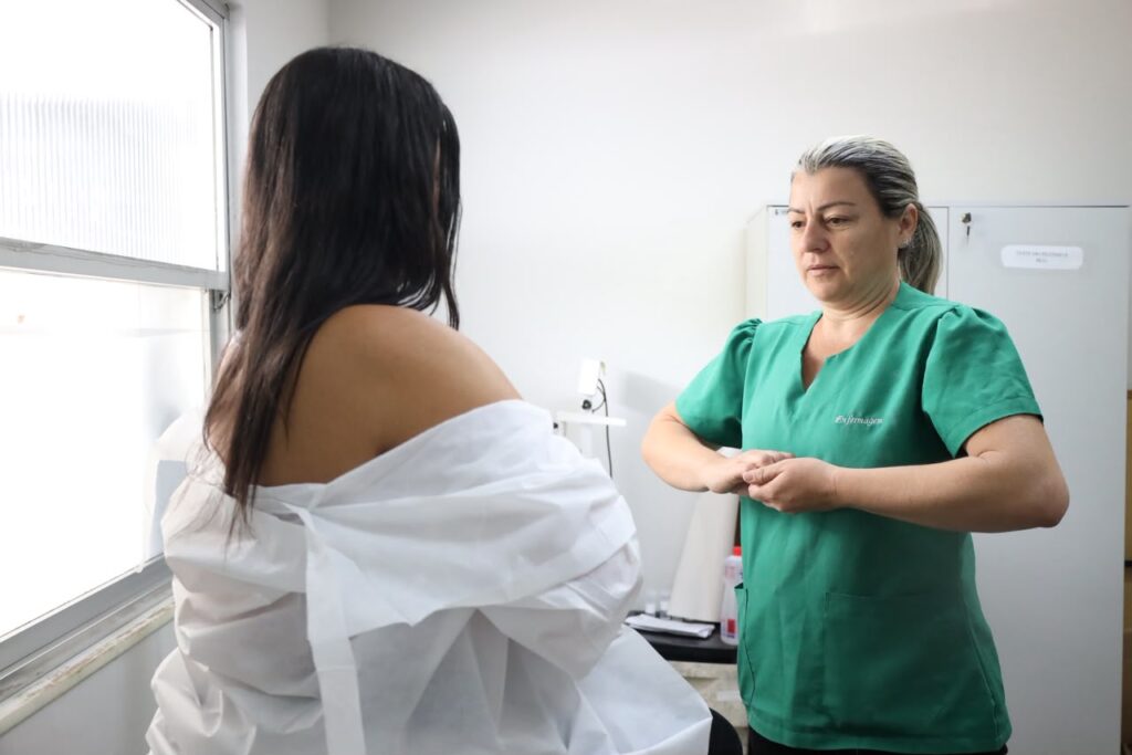 Mulheres em atendimento de saúde durante ação do Outubro Rosa em Niterói, focando na prevenção e diagnóstico precoce.