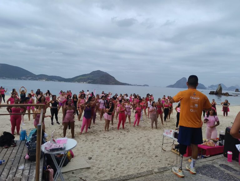 Mulheres participam de atividades físicas e de bem-estar na Praia de Icaraí, em Niterói, durante evento do Outubro Rosa.