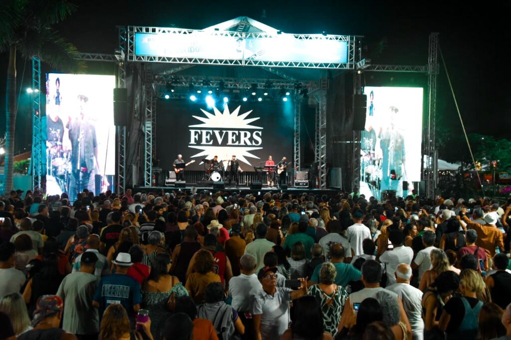 Público dança e se diverte durante show da banda The Fevers na Praça Orlando de Barros Pimentel, em Maricá.