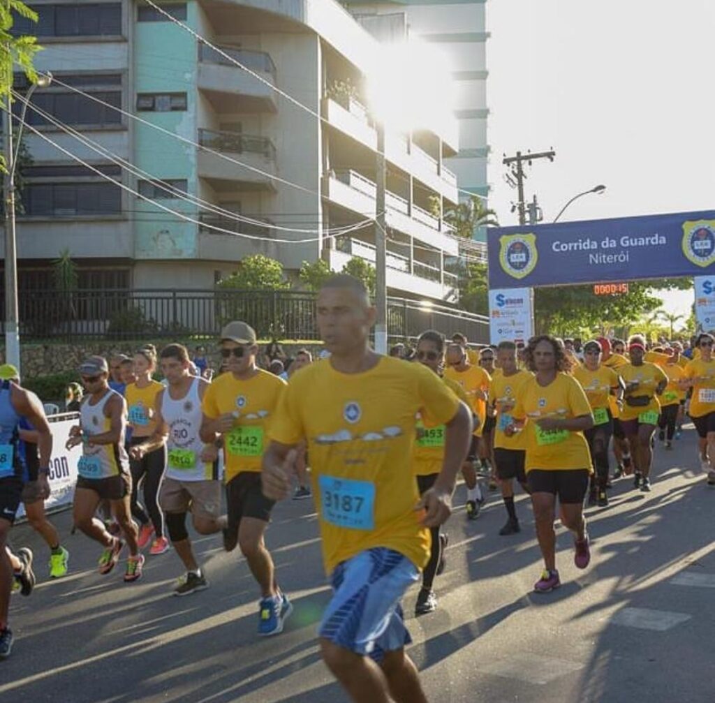 Corredores participam da Corrida da Guarda Municipal de Niterói em Piratininga, com sol e famílias.