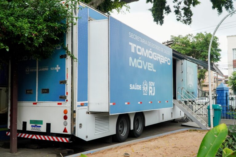 Carreta de tomografia computadorizada estacionada na Praça Zé Garoto em São Gonçalo, com pacientes aguardando atendimento.
