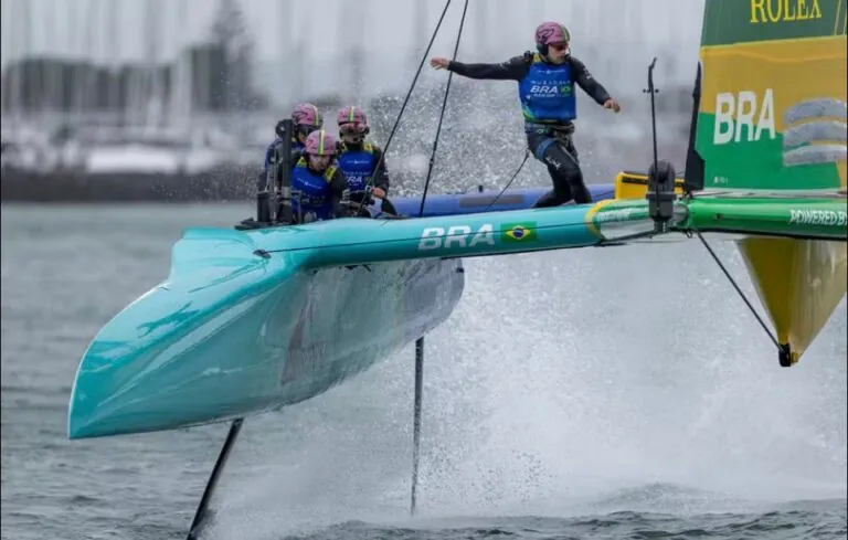 Catamarãs F50 de alta velocidade competem em corrida de vela na Baía de Guanabara, com Niterói como base de apoio logístico.