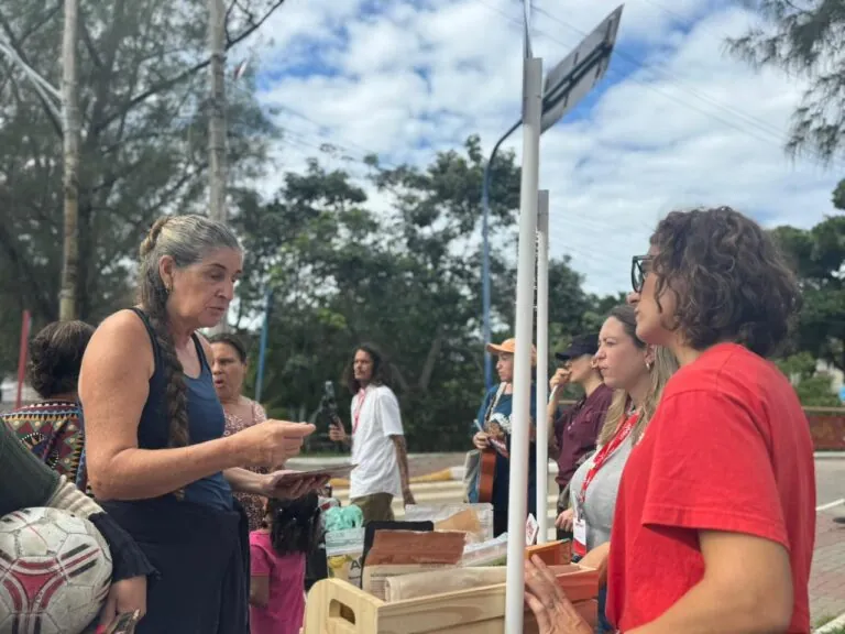 Moradores de Maricá visitam estande do projeto Amar nos Bairros com produtos da agricultura familiar.