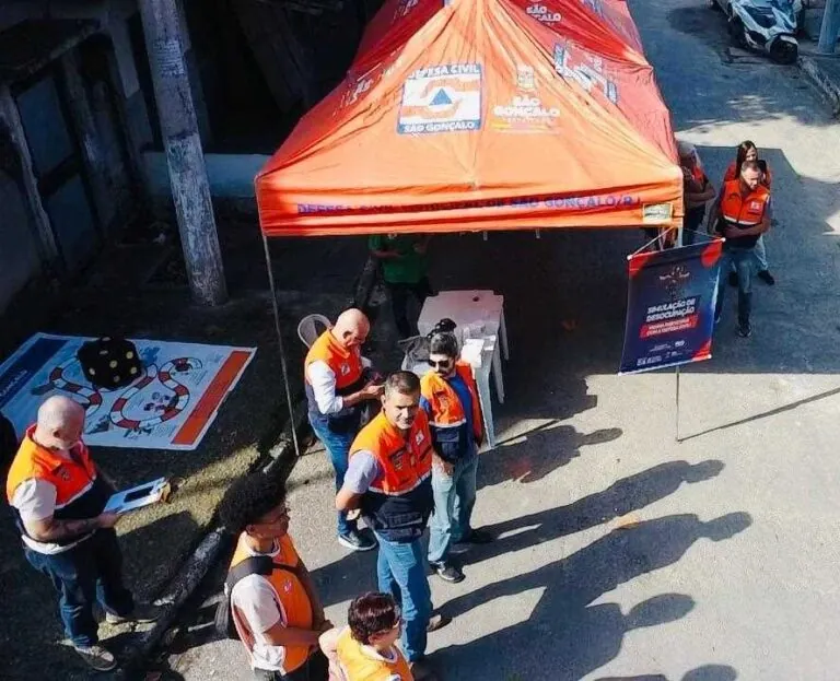 Moradores de São Gonçalo participam de simulado de desocupação da Defesa Civil no bairro Novo México, recebendo orientações.