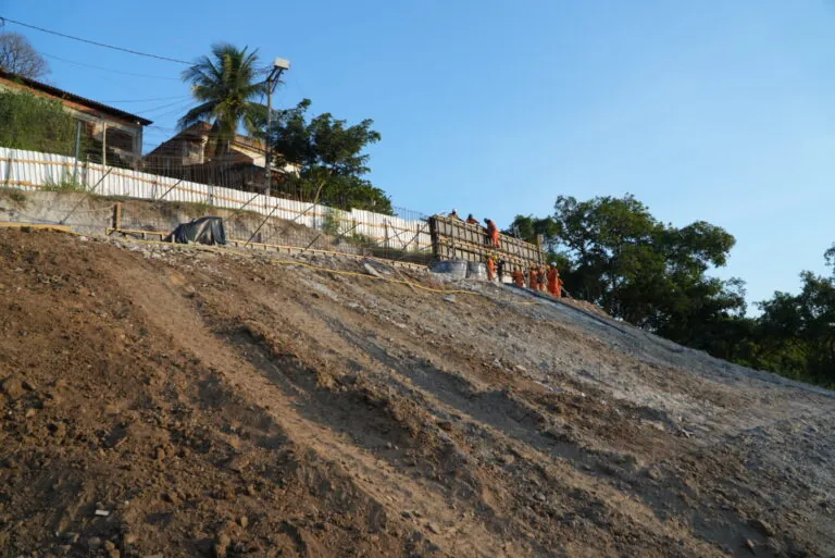 Trabalhadores em obra de contenção de encosta na Rua Vinte e Sete de Julho, bairro Lindo Parque, São Gonçalo.