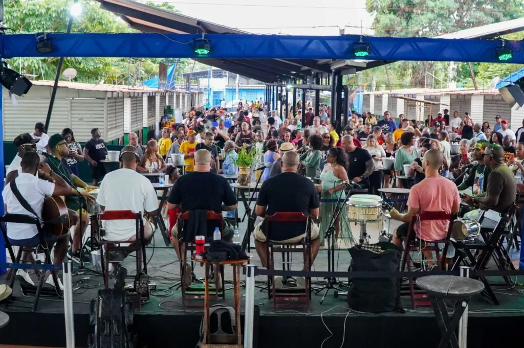 Artistas se apresentando em palco iluminado durante festival de música em São Gonçalo.