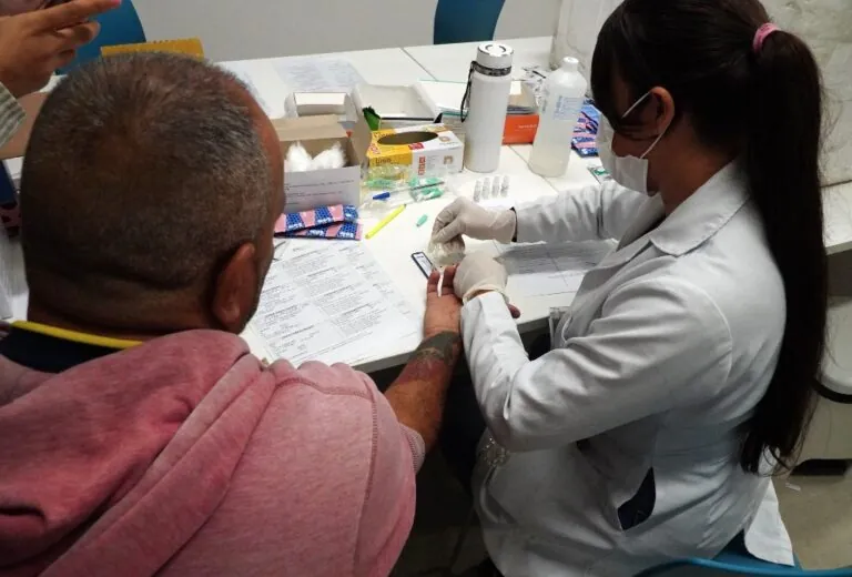 Profissional de saúde realiza atendimento a funcionário durante ação da Prefeitura de São Gonçalo.
