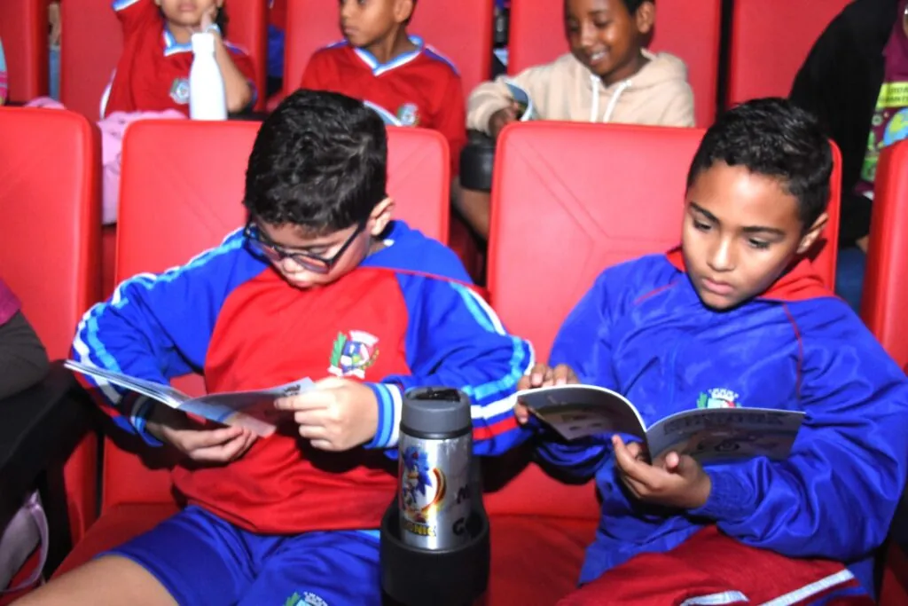 Crianças e autoridades no lançamento do livro infantil Aventuras em Maricá sobre educação ambiental