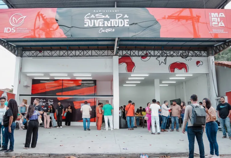 Jovens participam de atividades e cursos em uma Casa da Juventude em Maricá, com computadores e instrumentos musicais.