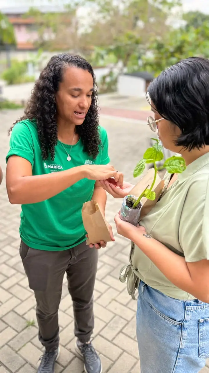 Produtores e consumidores interagem na Feira da Agricultura Familiar em Maricá, com alimentos frescos à venda.