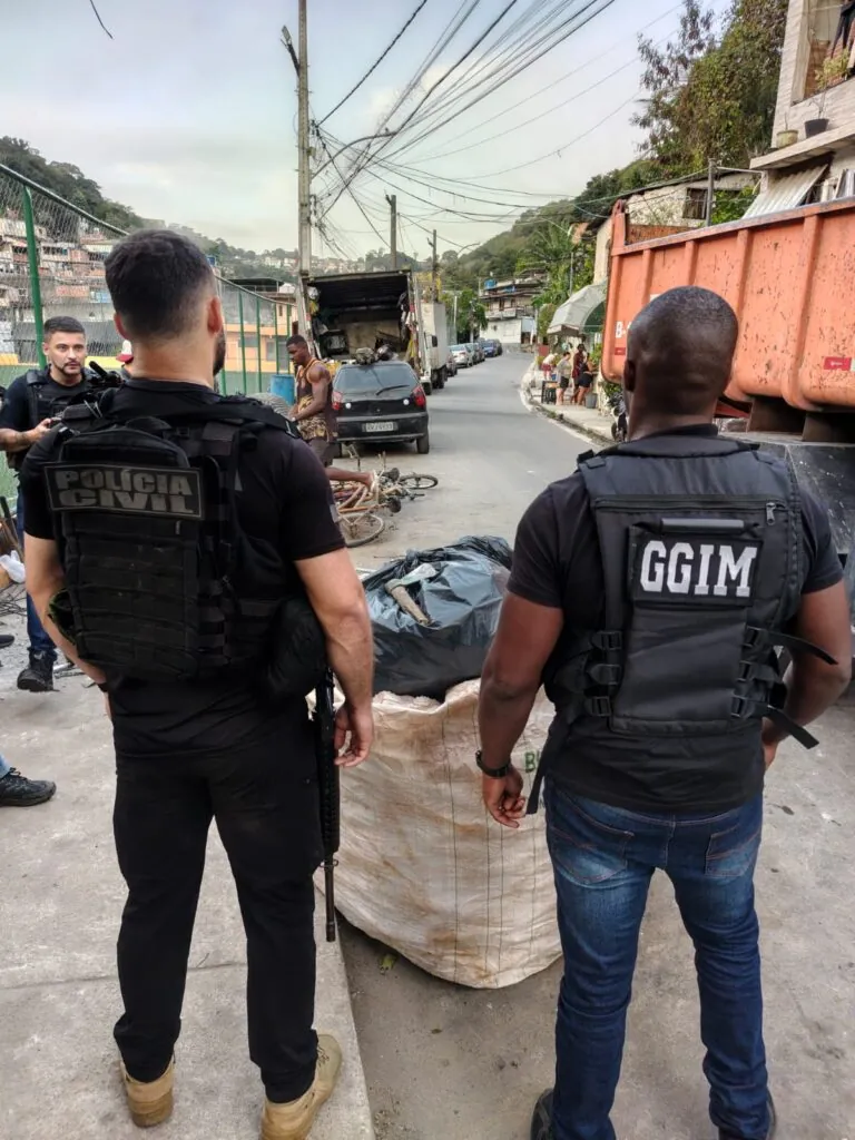 Agentes da segurança e fiscais em operação contra ferro-velho clandestino na Grota, Niterói, apreendendo materiais furtados.